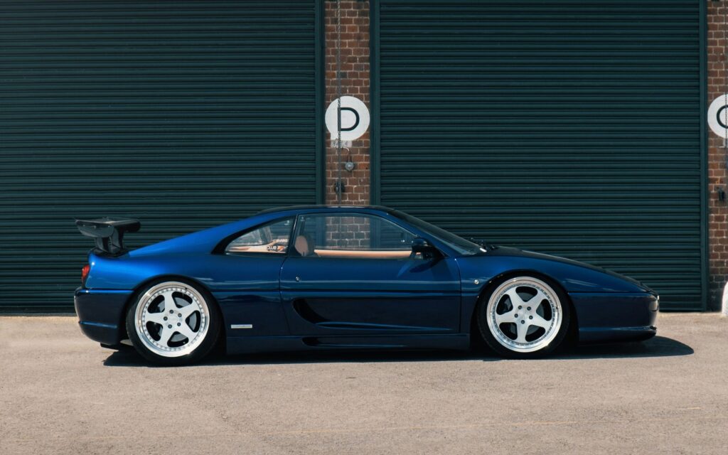 A side profile view of a dark blue Ferrari F355