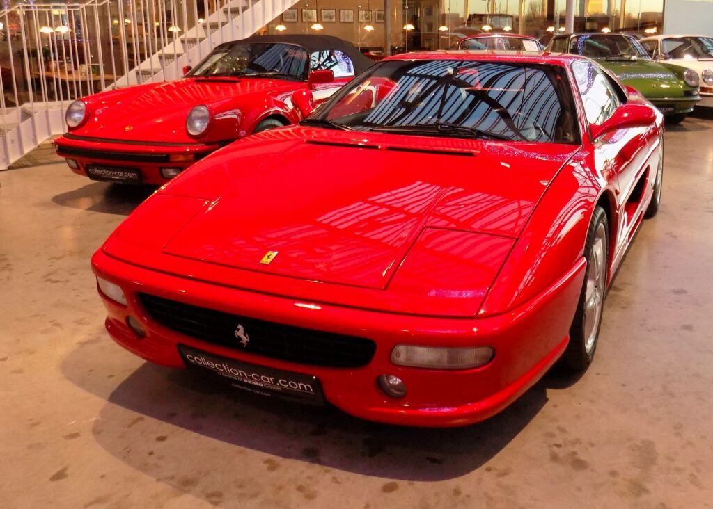 A red Ferrari F355 paked next to a red Porsche 930.