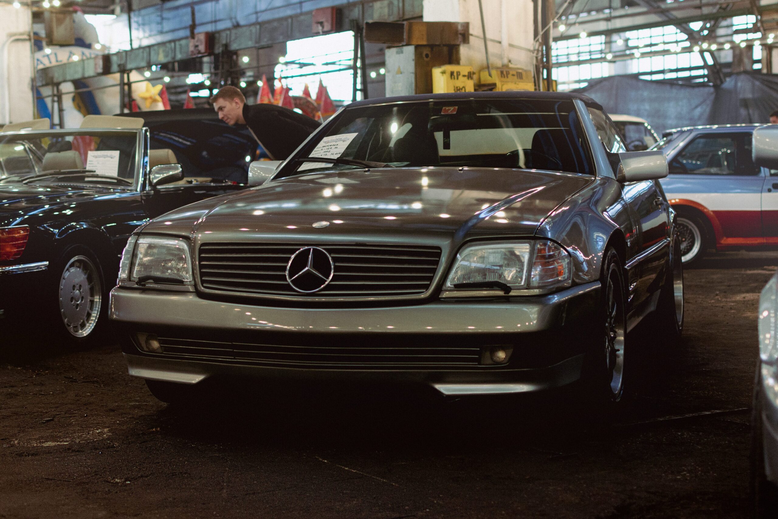 Gold Mercedes R129 Investment car parked at a meet.