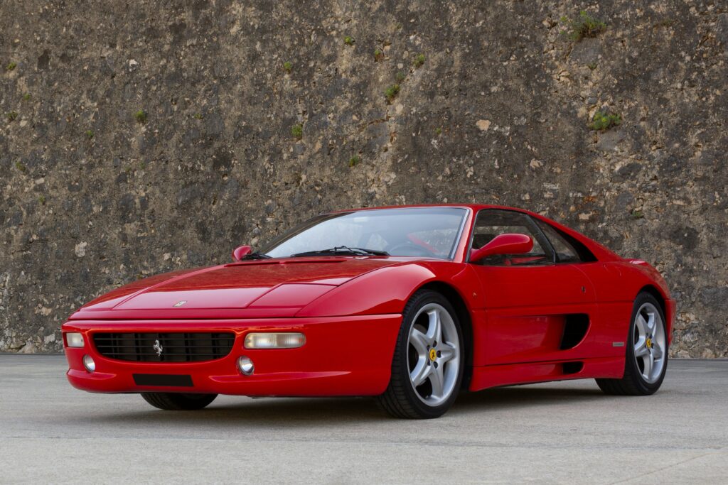 A red Ferrari F355 parked outside.