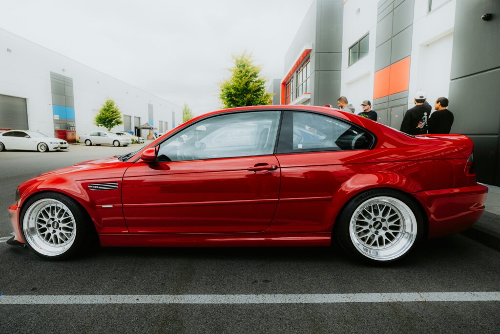 A side-profile view of a red BMW E46 M3