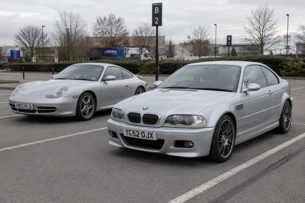 BMW E46 M3 vs Porsche 996 Carrera parked next to each other at a public car park.