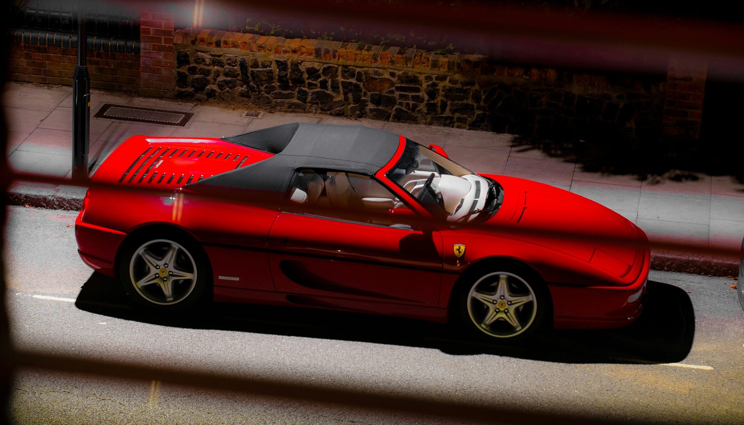 An aerial shot of a red Ferrari F355 Spider.