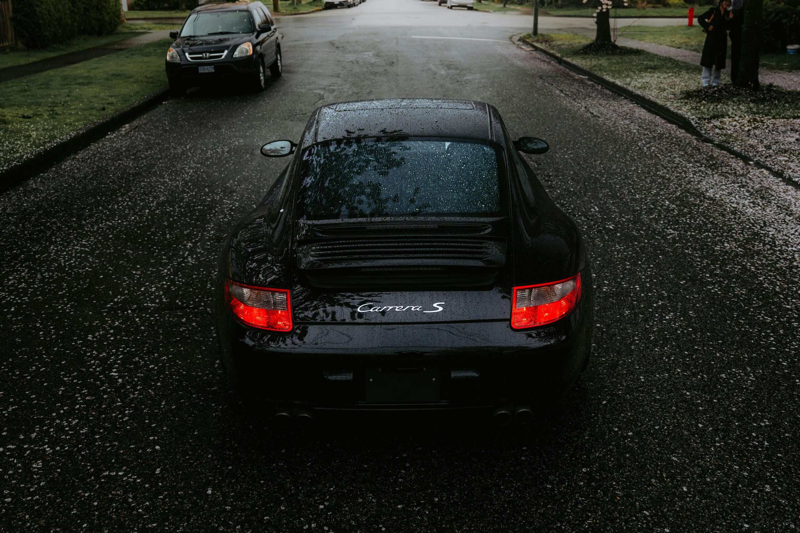 A rear-end view of a black Porsche 996 911.