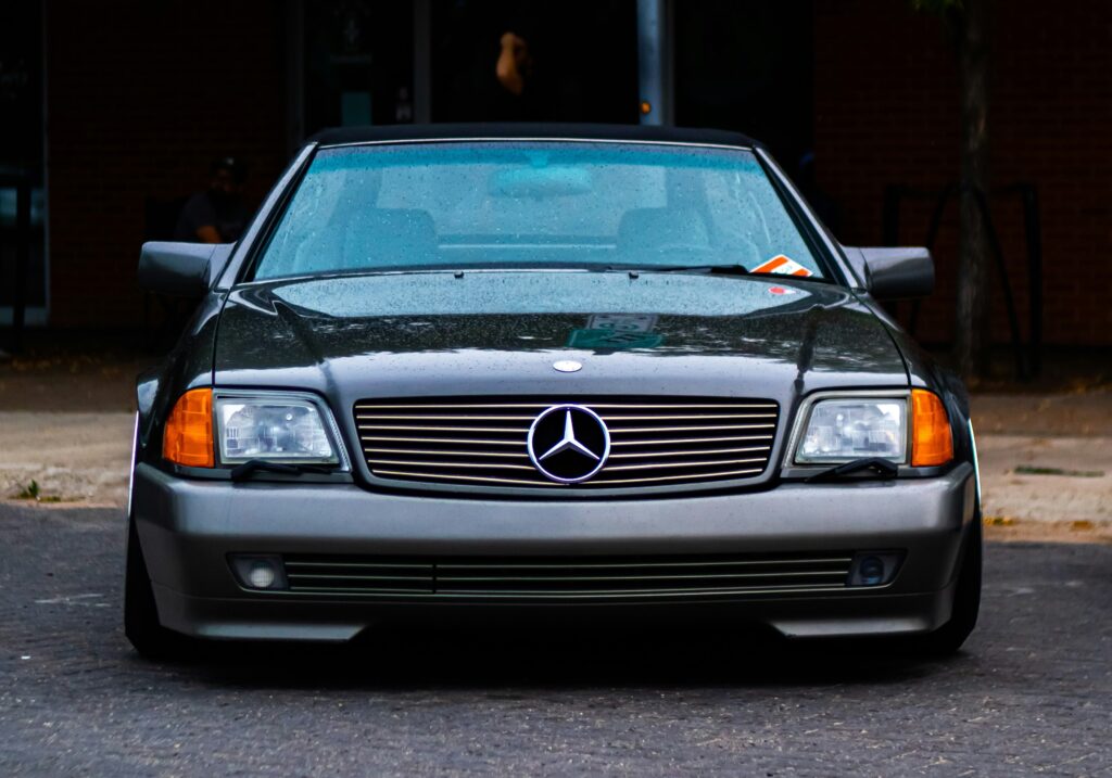 A front-facing shot of a two-tone Mercedes SL R129.