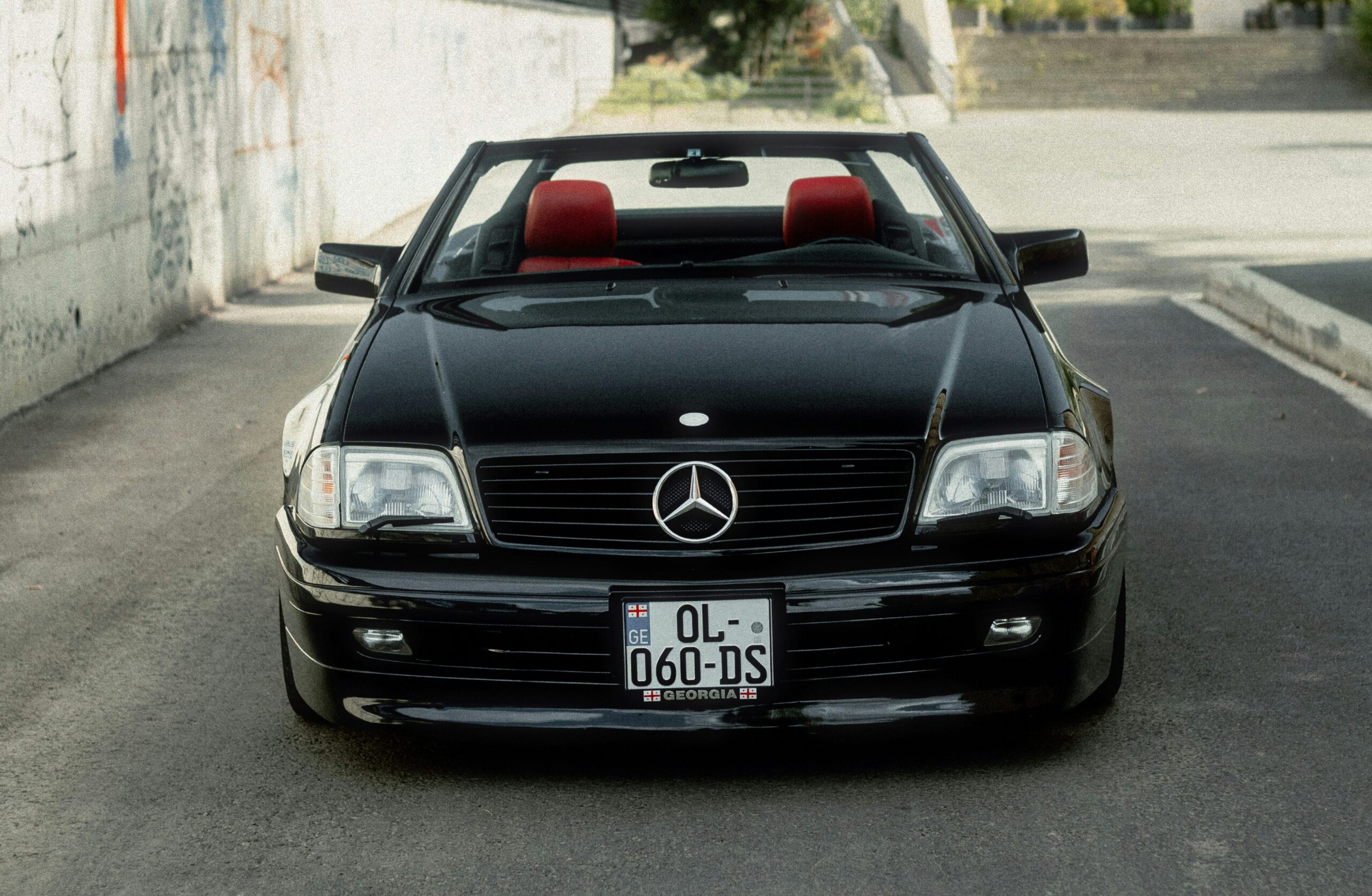 A front-facing shot of a black Mercedes R129.
