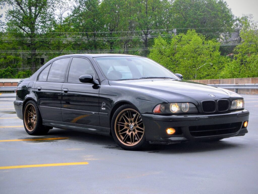 A black BMW E39 M5 parked on the street.