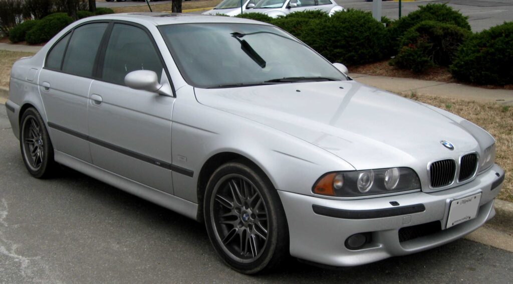 Silver BMW M5 E39 aparked on a road.