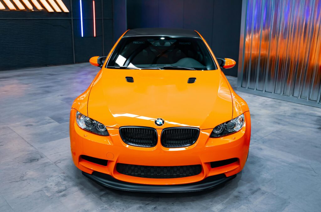 Front-end view of on orange BMW E92 M3 GTS parked on display