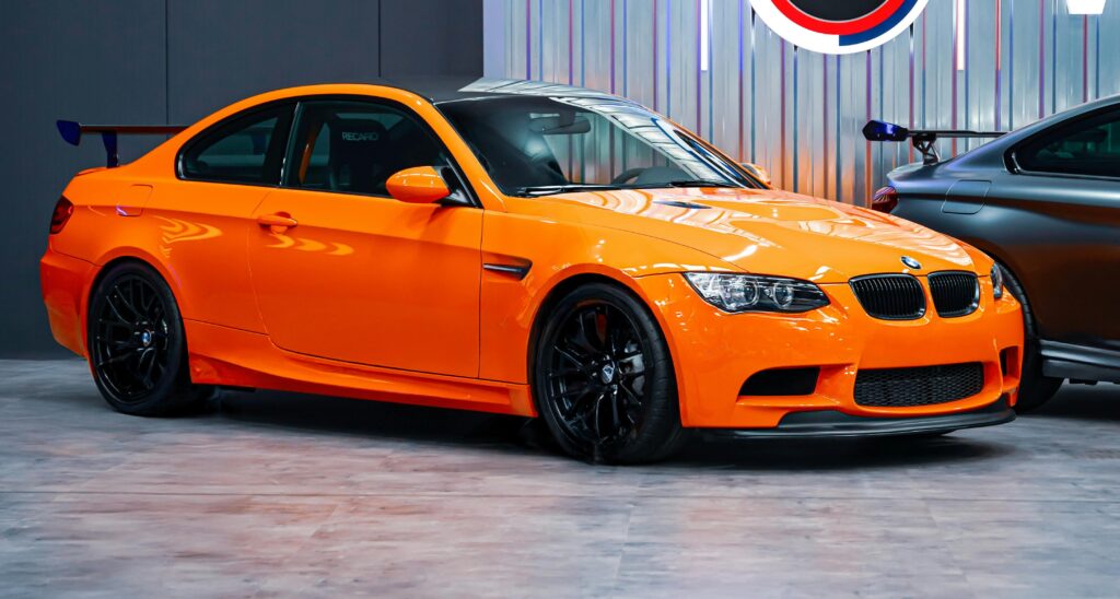 An orange BMW E92 M3 GTS parked on display