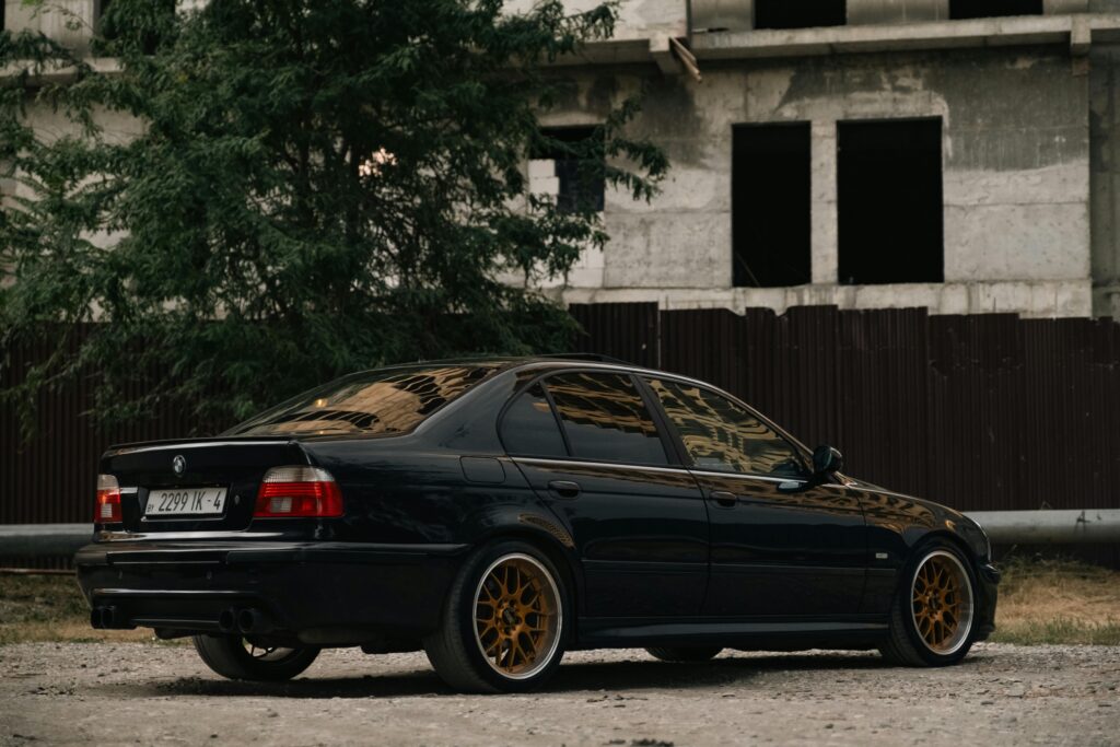 A rear three-quarter view of a black BMW E39 M5.