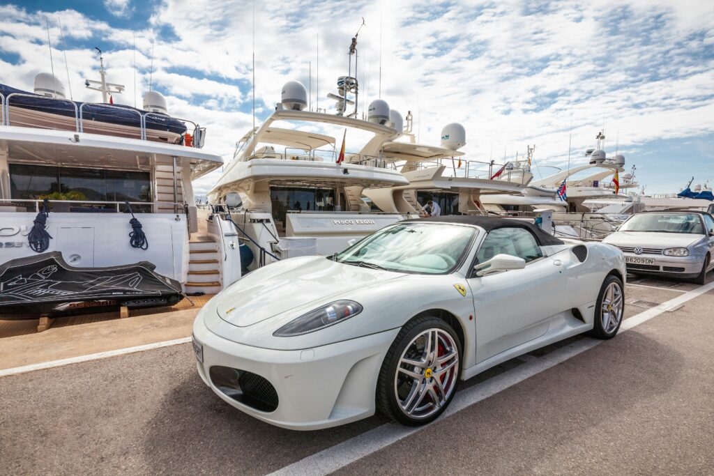 A white Ferrari F430 Spyder parked in a marina.