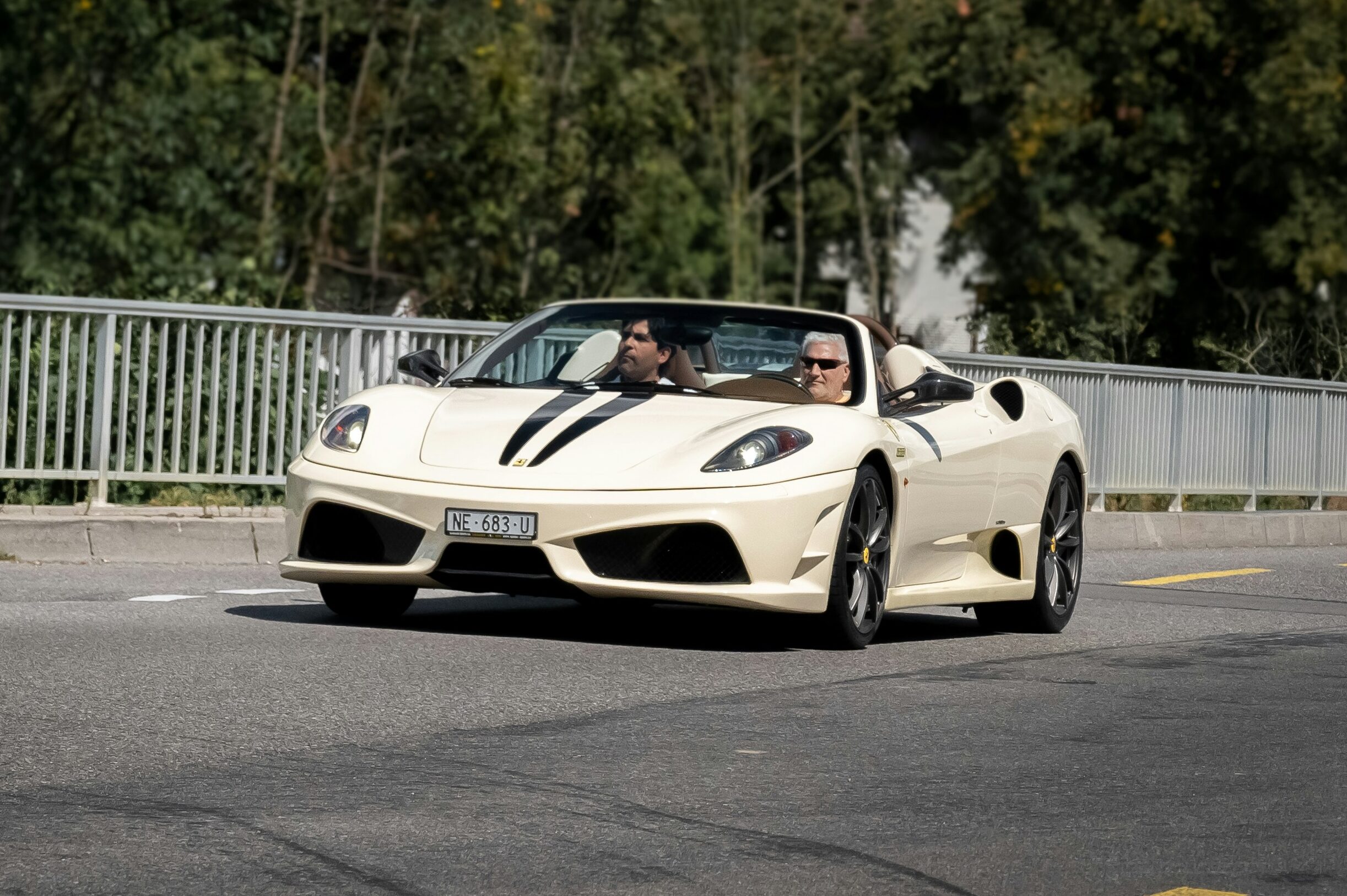 A crema white Ferrari F430 Scuderia 16M driven on the road.