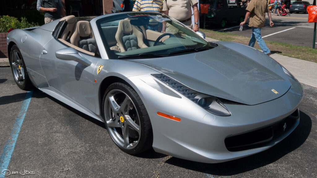 A silver Ferrari 458 Spider parked.
