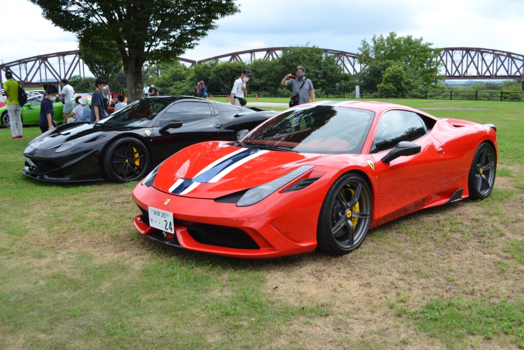 A red Ferrari 458 Speciale parked to a tuned black Ferrari 458 Italia.