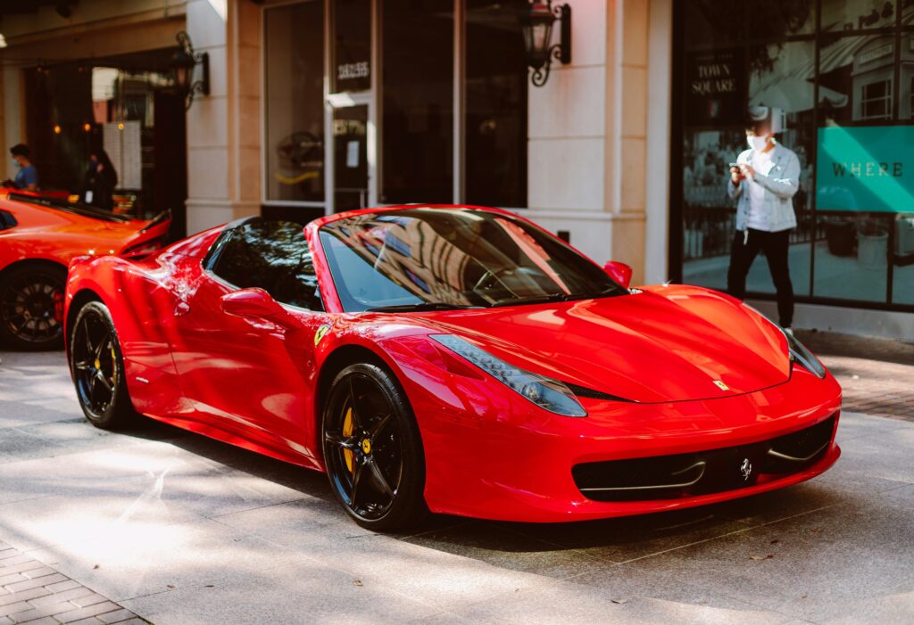 A red Ferrari 458 Spider parked on a city street.