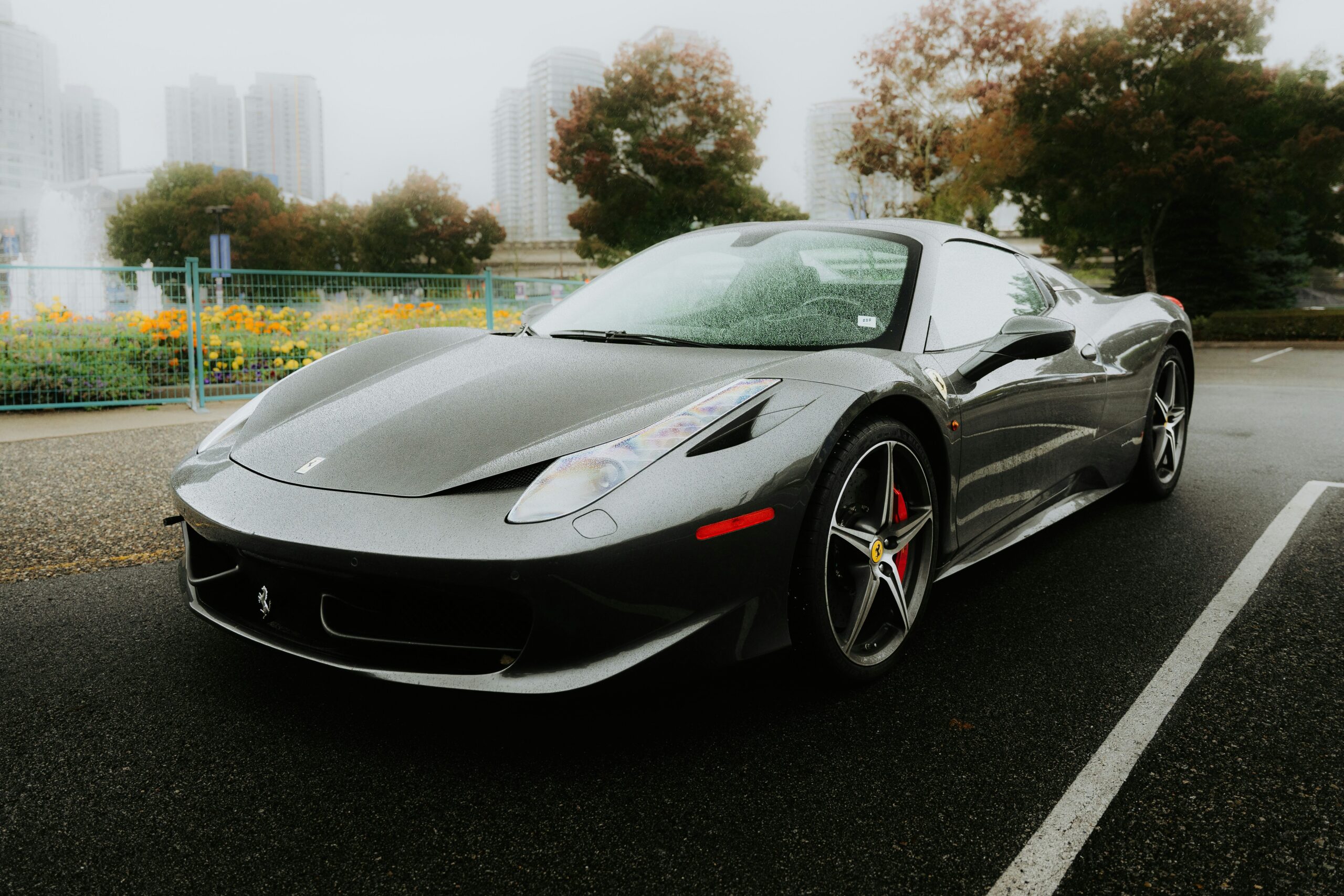 A gray Ferrari 458 Italia parked in the rain.