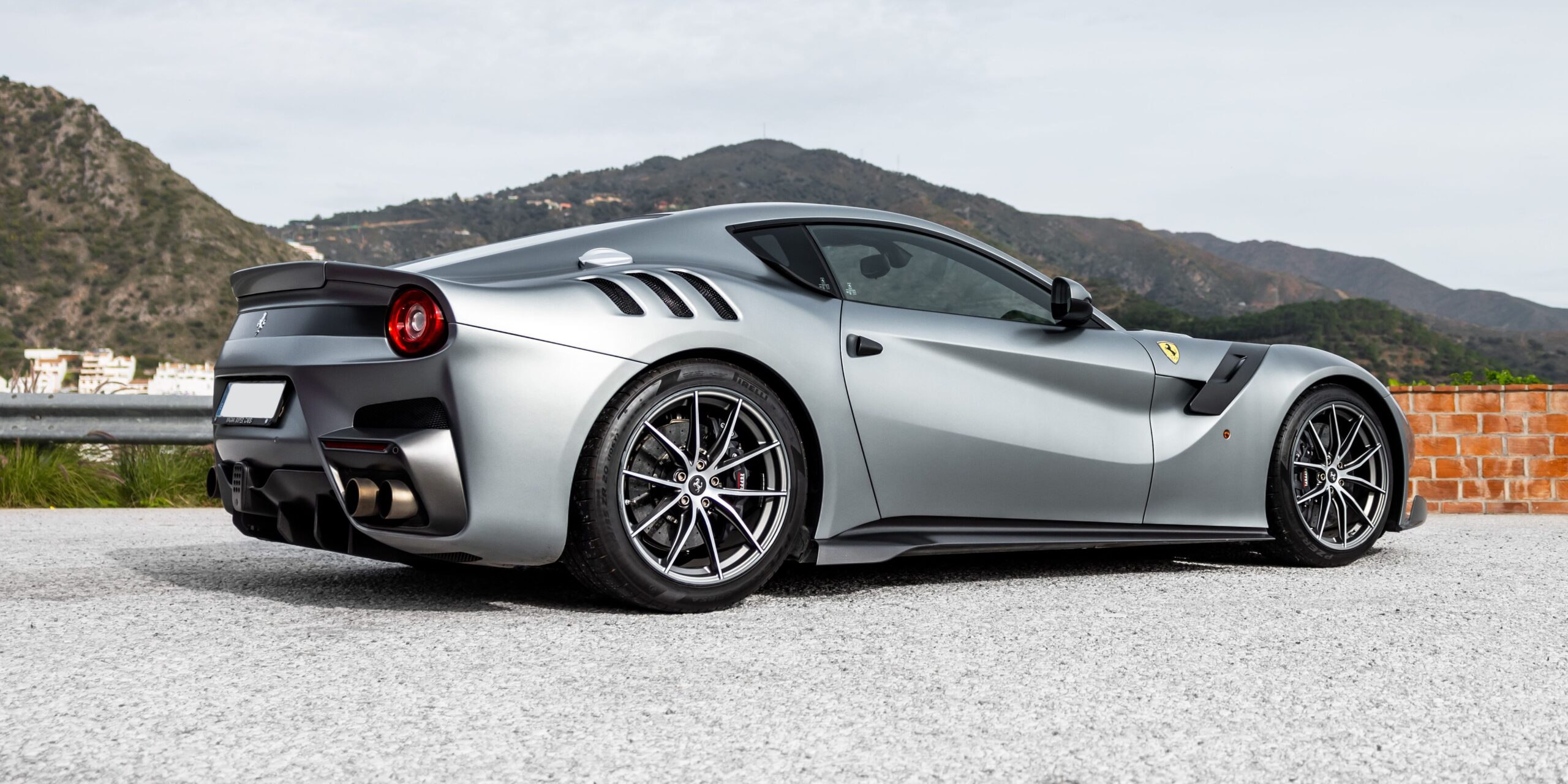 A rear three-quarter view of a gray Ferrari F12 TDF